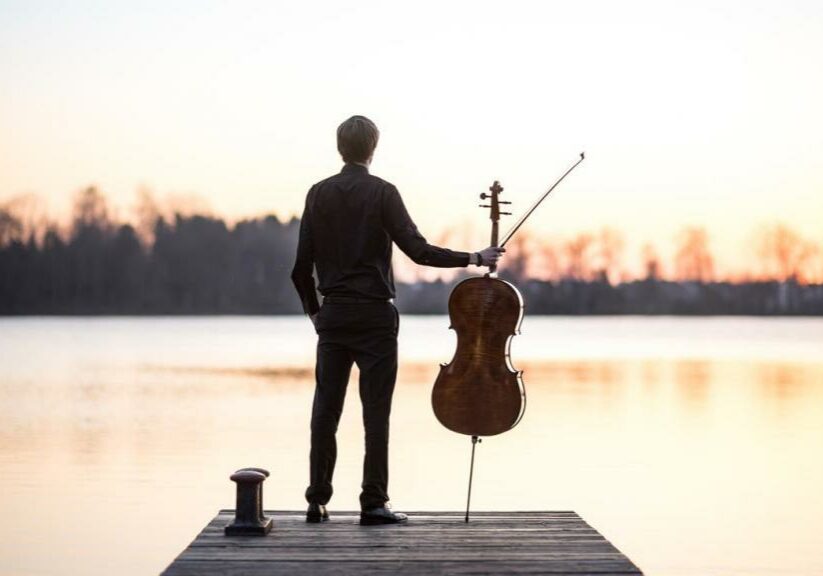 A musician standing in front of a beautiful lake